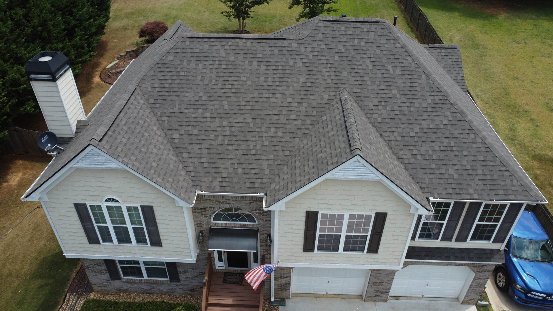 An aerial view of a large house with a car parked in front of it.