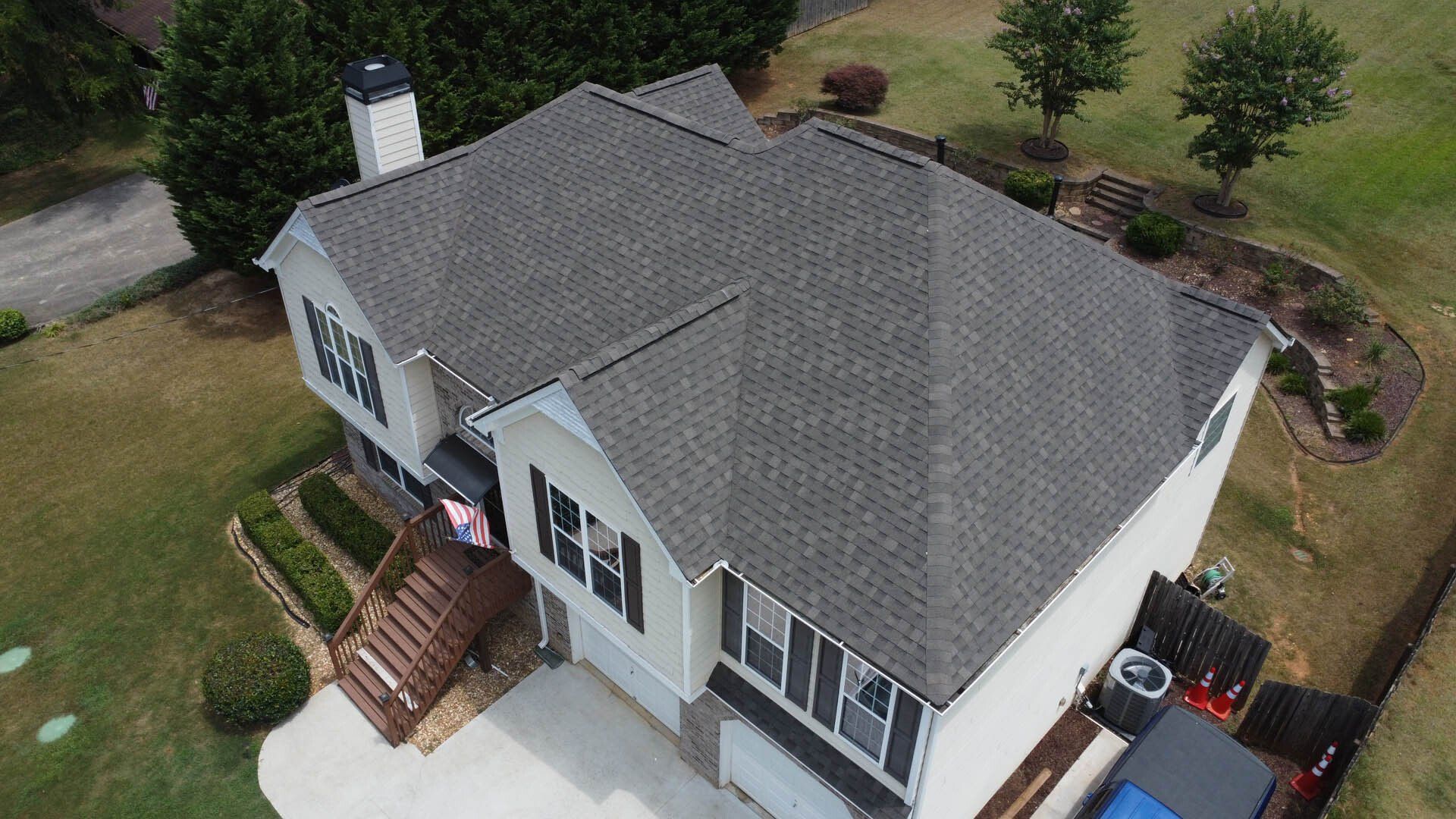 An aerial view of a large white house with a gray roof.