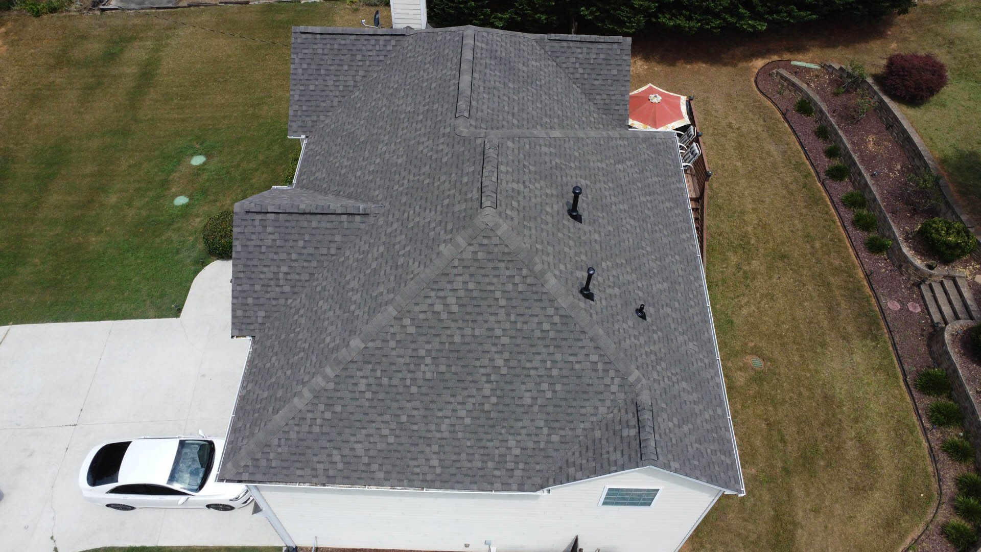 An aerial view of a house with a car parked in front of it.