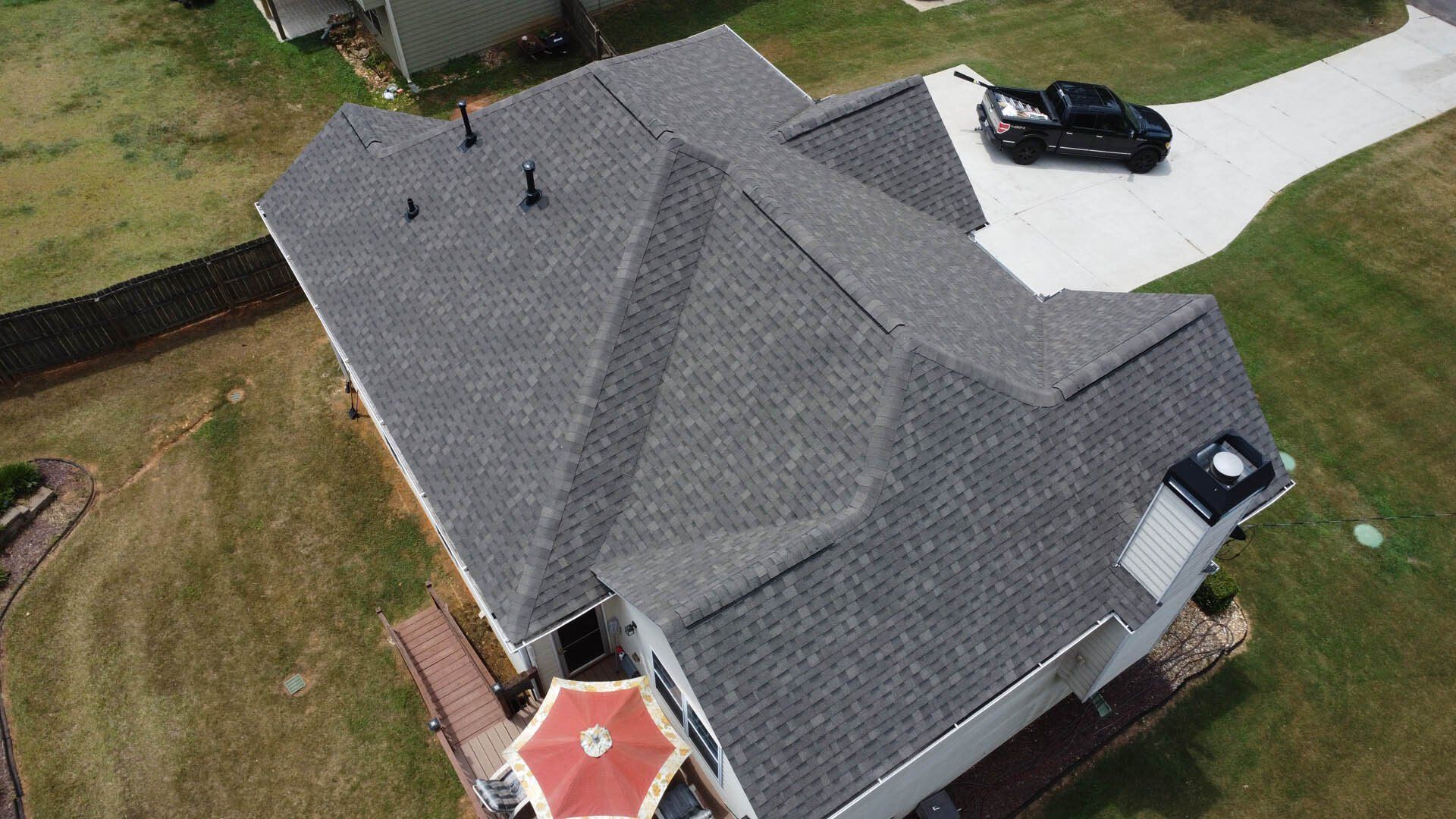 An aerial view of a house with a truck parked in the driveway.