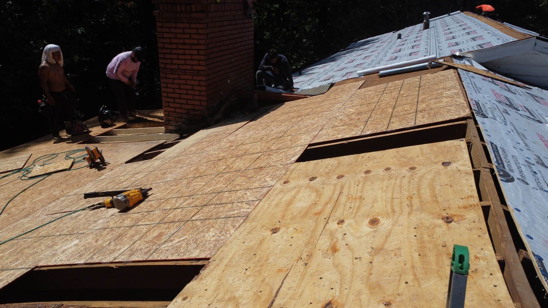 A man is working on a roof with a drill and a saw.