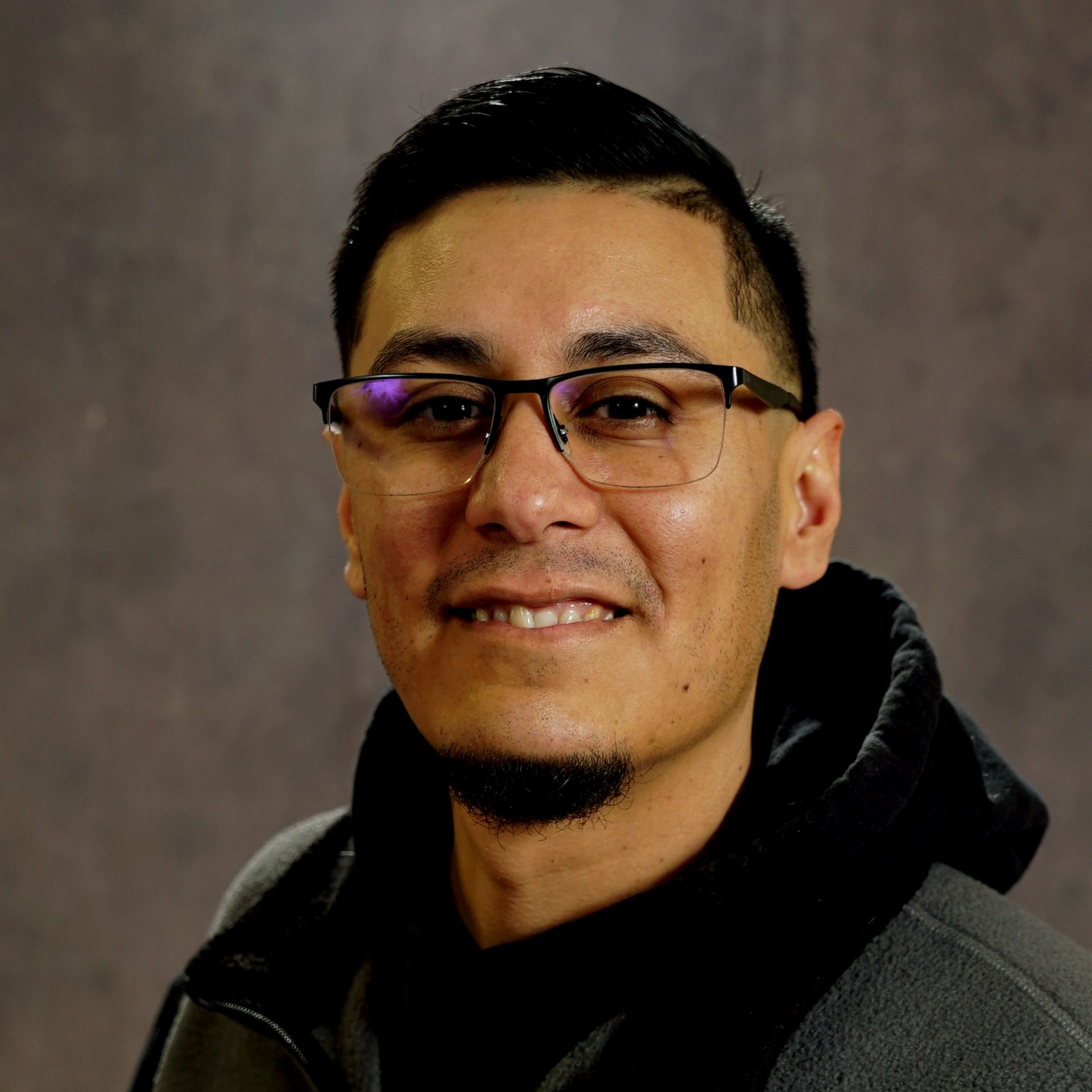 A bald man wearing a blue shirt is smiling for the camera.