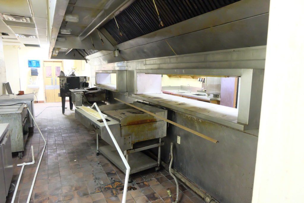 An empty kitchen with a lot of appliances and a window.