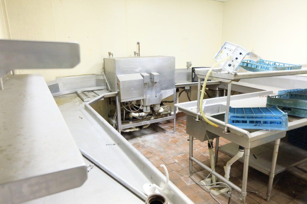 A kitchen with a lot of stainless steel appliances and sinks.