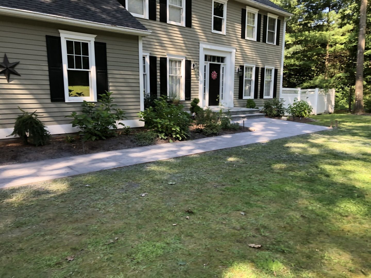 A large house with a walkway leading to the front door.