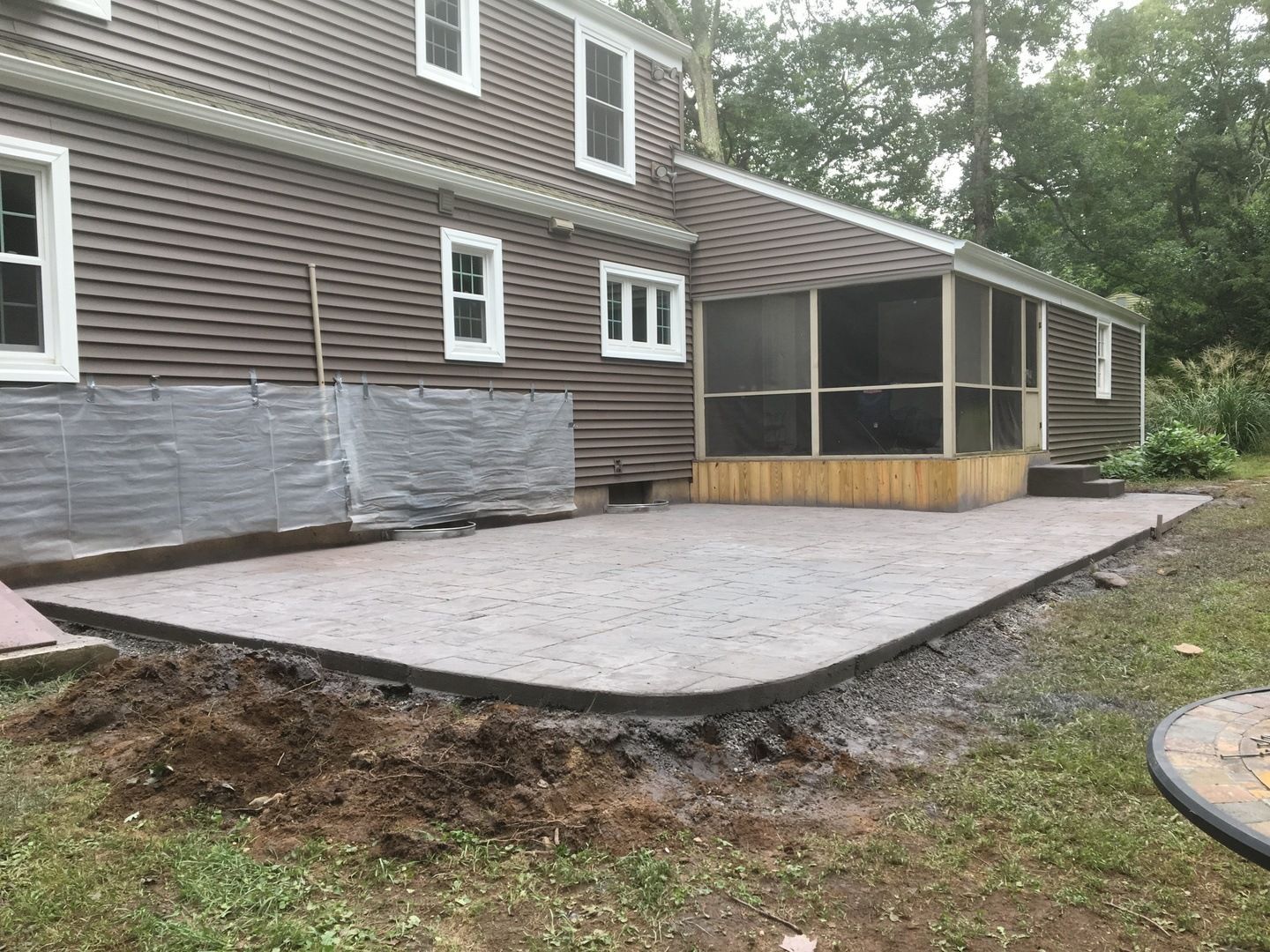 A screened in porch is being built in front of a house