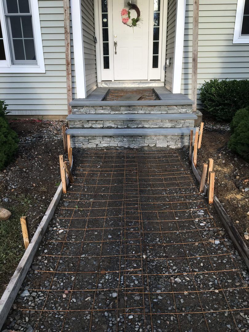A concrete walkway leading to the front door of a house.