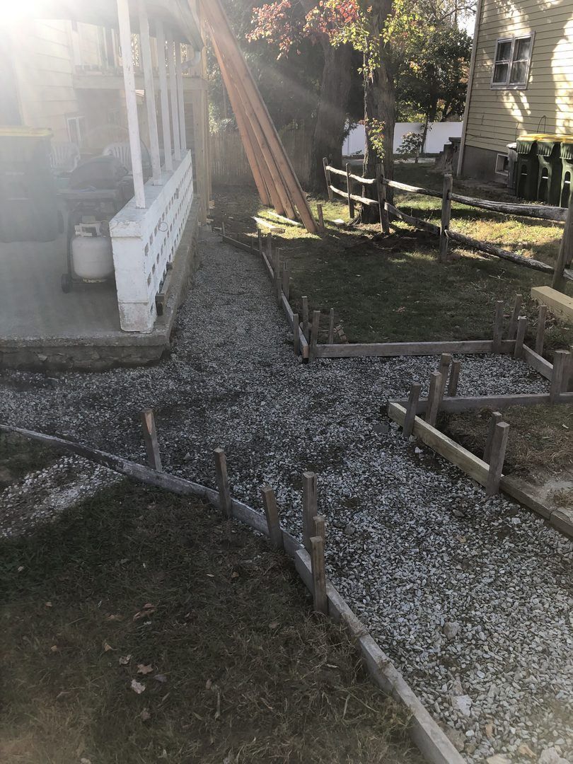 A concrete walkway is being built in front of a house.