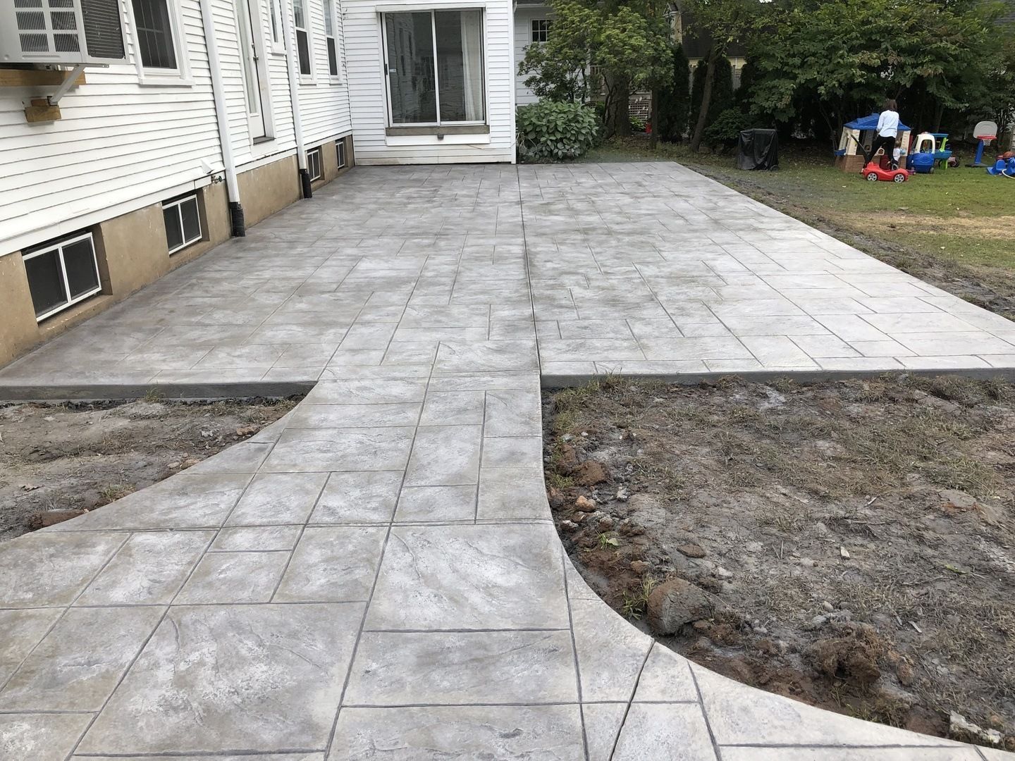 A concrete walkway is being built in front of a house.
