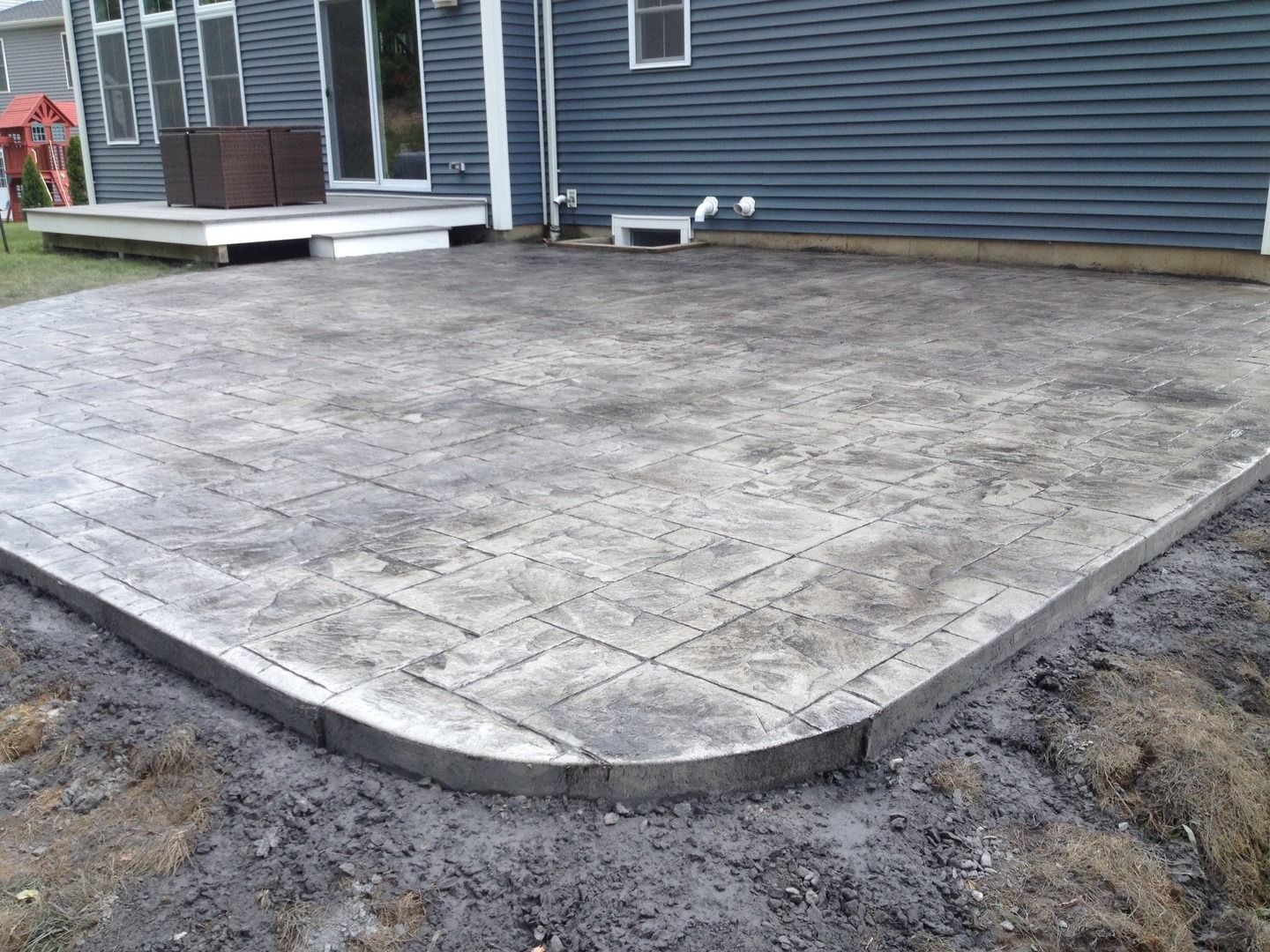 A concrete patio is being built in front of a house.