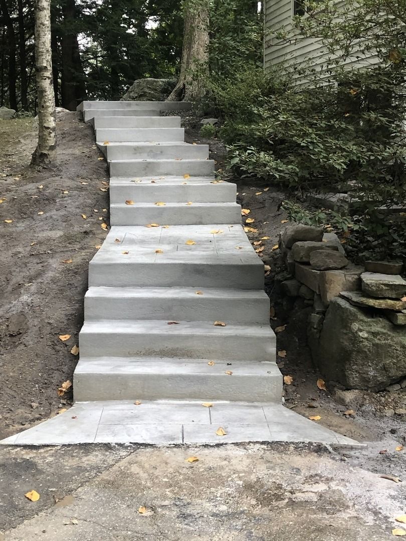 A set of concrete stairs leading up to a house.