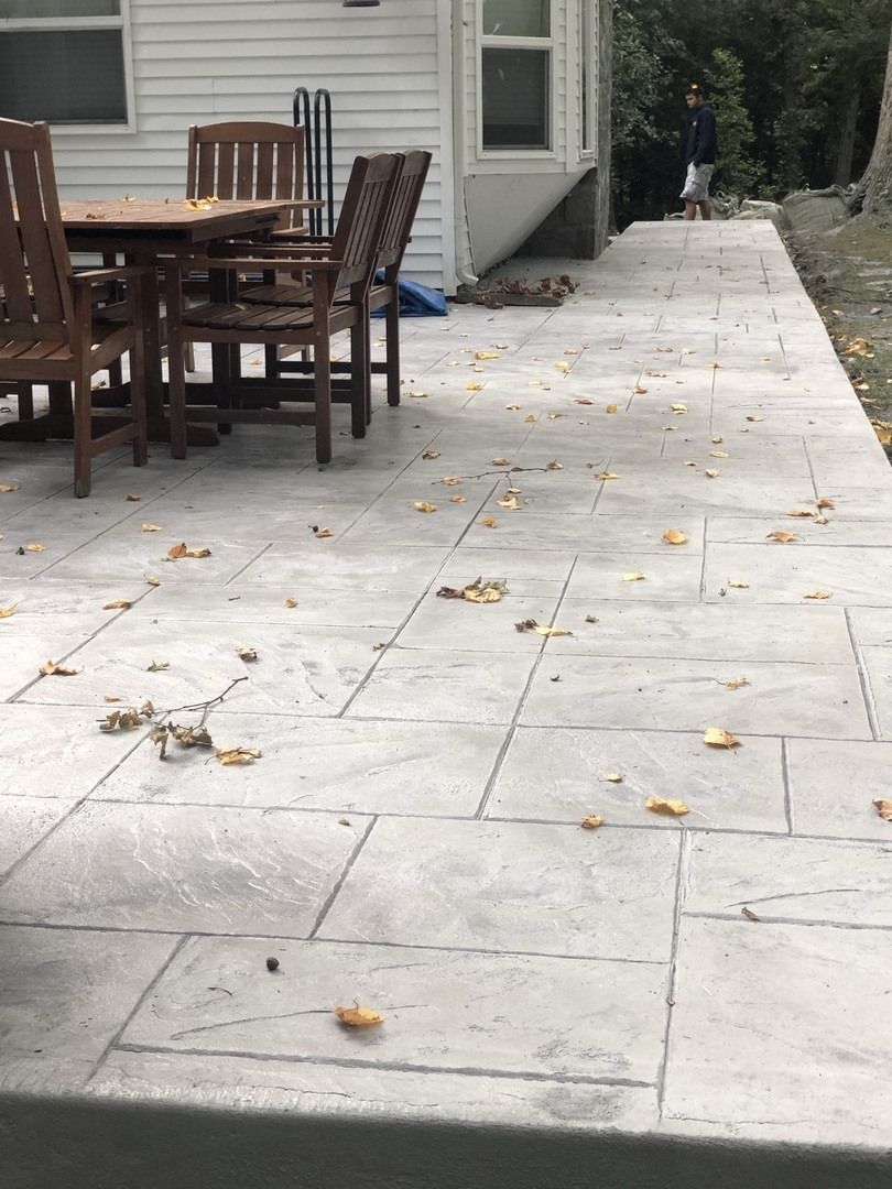 A patio with a table and chairs in front of a house.