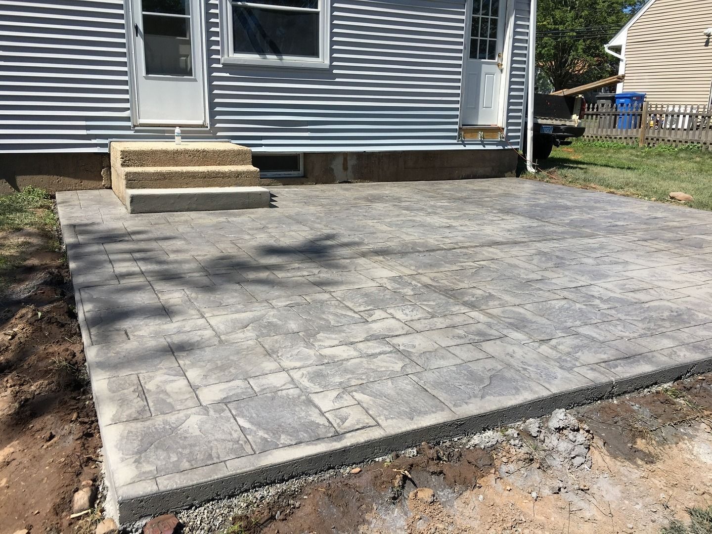 A patio is being built in front of a house.