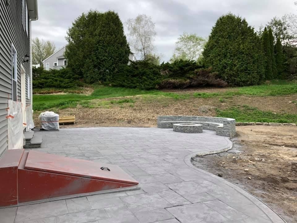 A patio is being built in the backyard of a house.