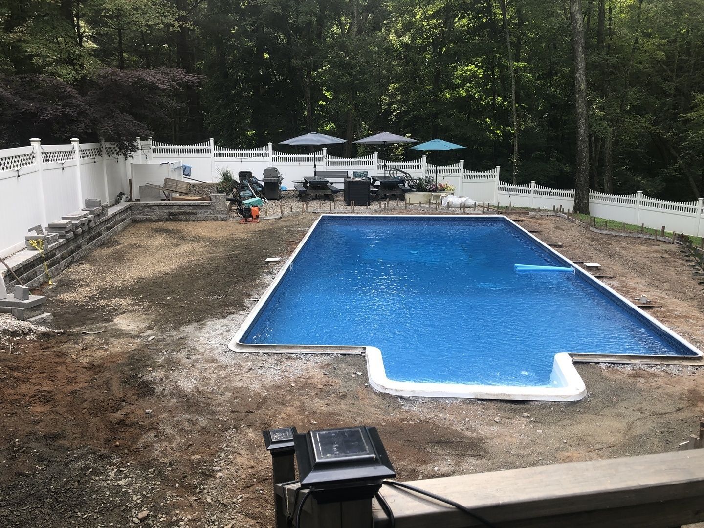 A large swimming pool is being built in a backyard.