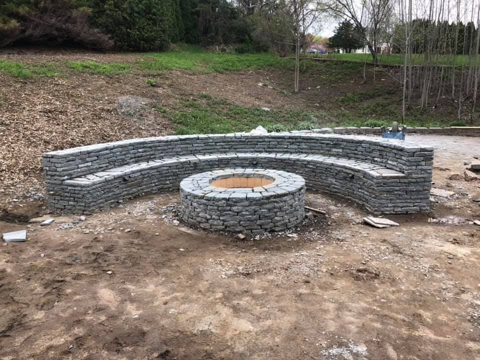 A stone wall with a fire pit in the middle of it.