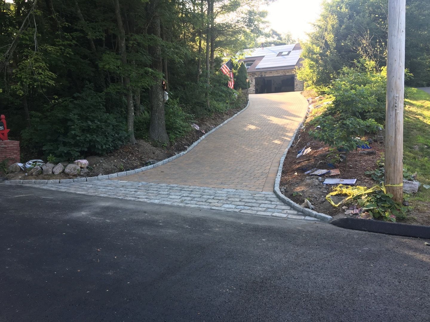 A driveway leading to a house surrounded by trees and bushes.