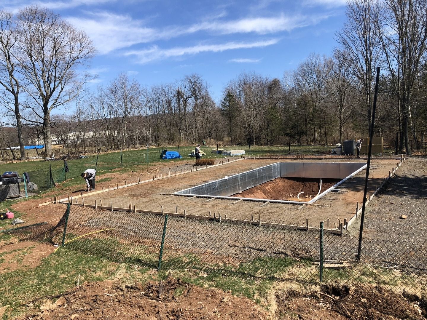 A large swimming pool is being built in the middle of a field.