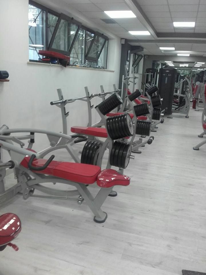Una palestra con molti attrezzi ginnici e una panca rossa