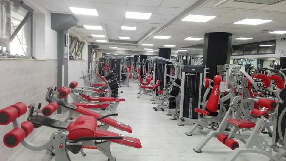 Una palestra piena di attrezzi ginnici rossi e argento.
