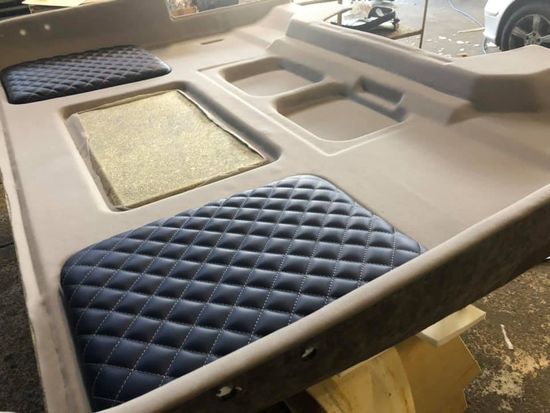 Un tavolo con un cuscino blu sopra e un'auto sullo sfondo