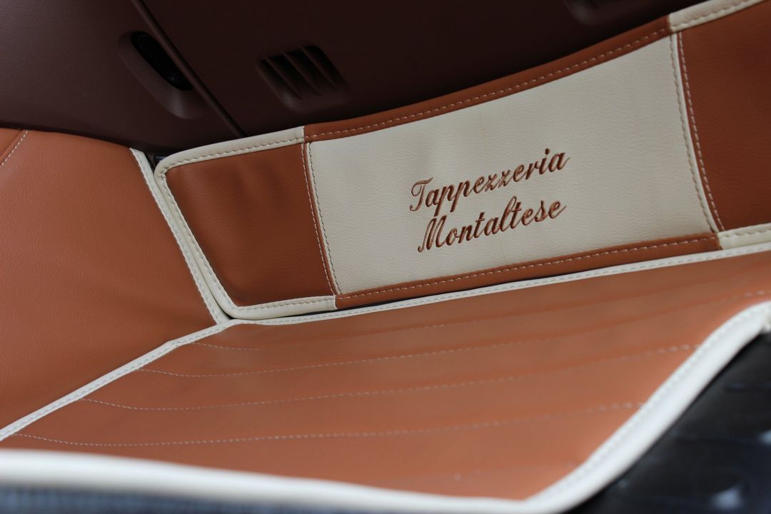 Un primo piano di un oggetto marrone e bianco con la scritta tappeggieria realtese