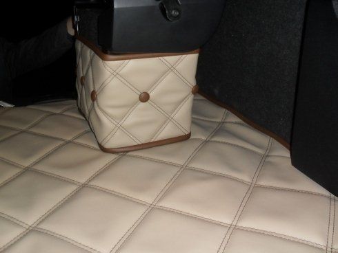 Un pouf trapuntato è appoggiato sul pavimento di un'auto