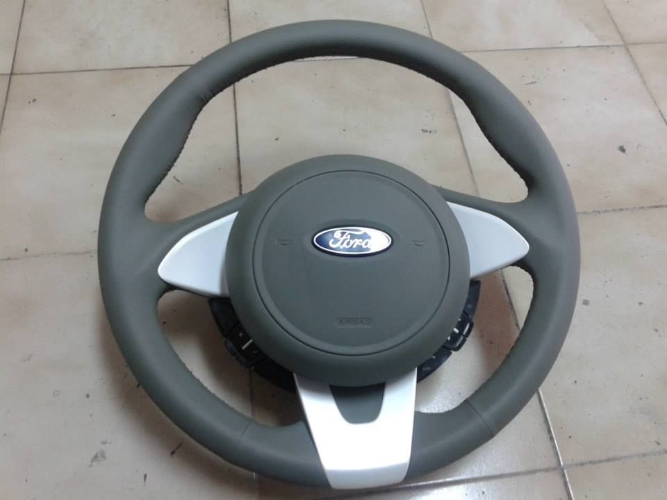 Un volante Ford poggia su un pavimento piastrellato