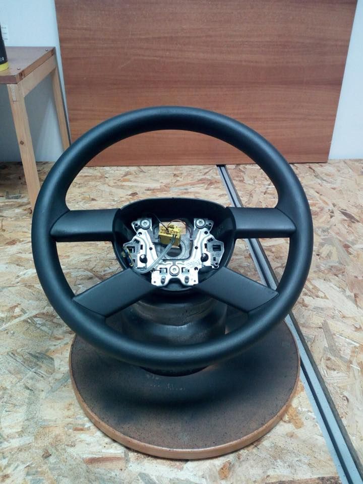 Un volante nero è appoggiato su un tavolo di legno