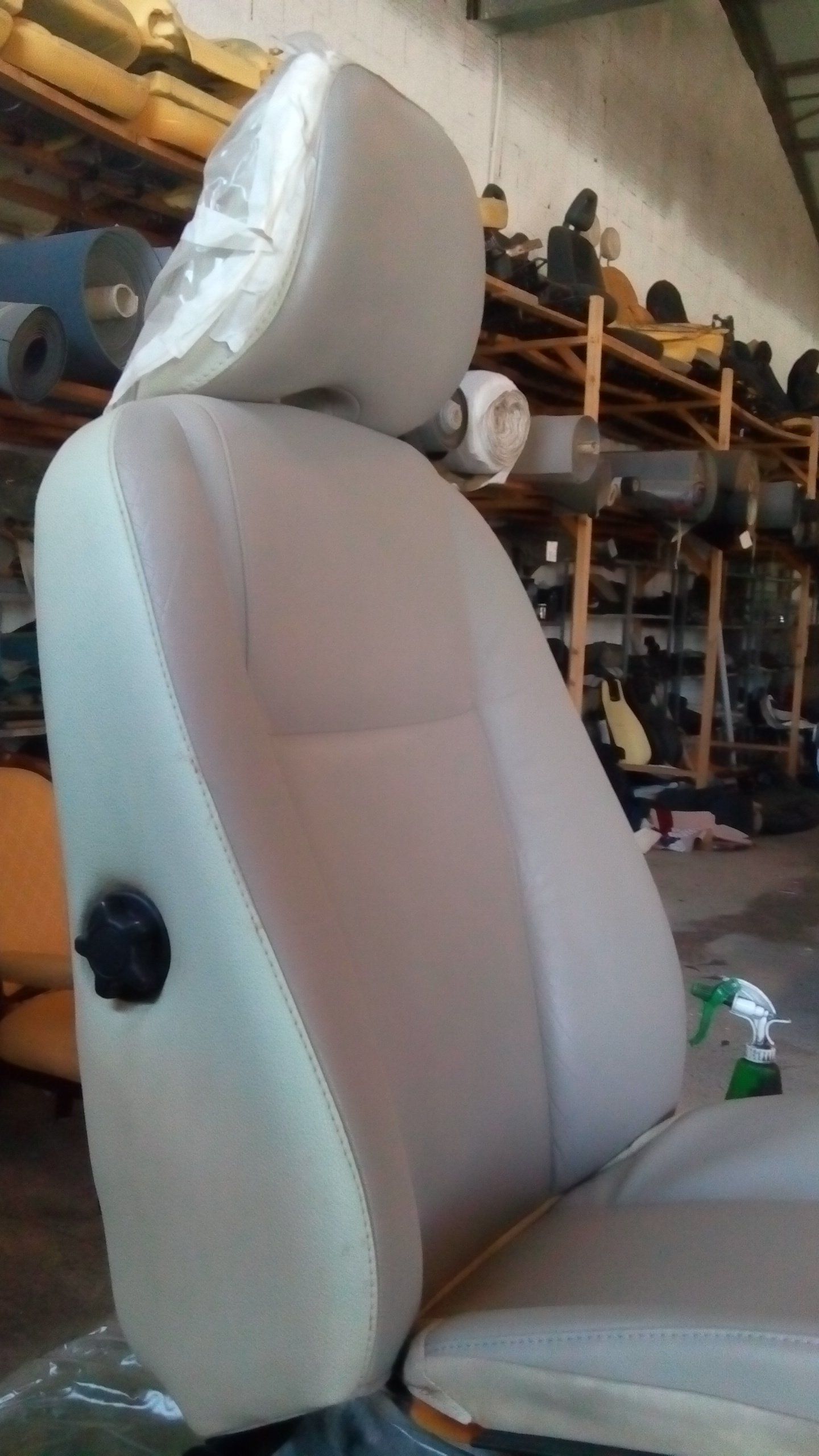Un sedile bianco per auto è parcheggiato in un magazzino.