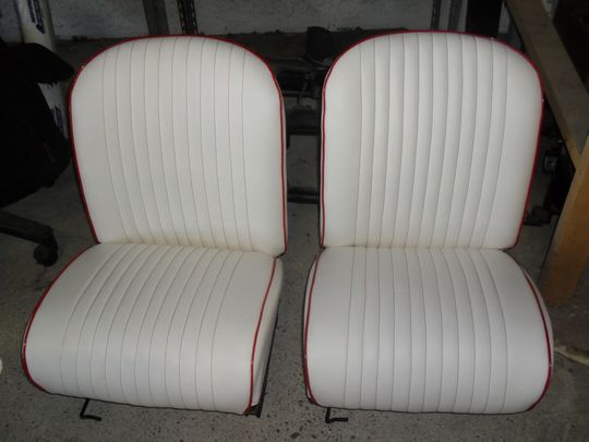 Un paio di sedili bianchi per auto con finiture rosse