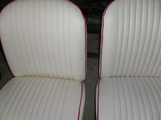 Un paio di sedili bianchi per auto con finiture rosse