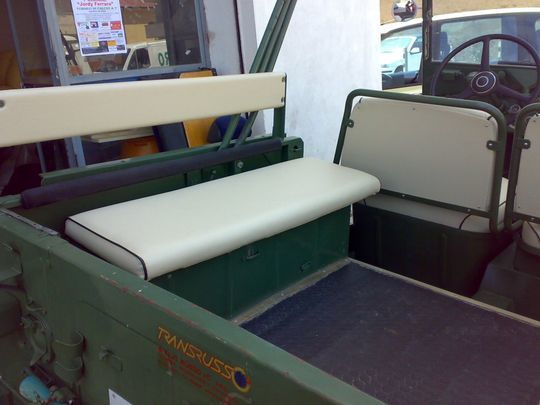 Un veicolo verde con un sedile bianco e un cartello che dice rimorchio