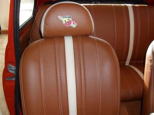 Un seggiolino auto marrone con una striscia bianca