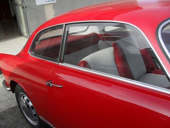 Un'auto rossa è parcheggiata davanti a un edificio