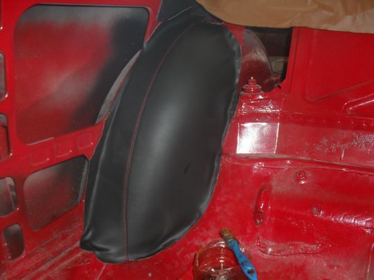 Un primo piano di un'auto rossa con un parafango nero