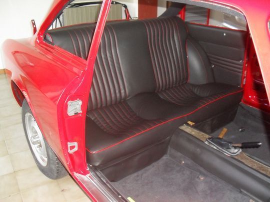 Il sedile posteriore di un'auto rossa con la portiera aperta