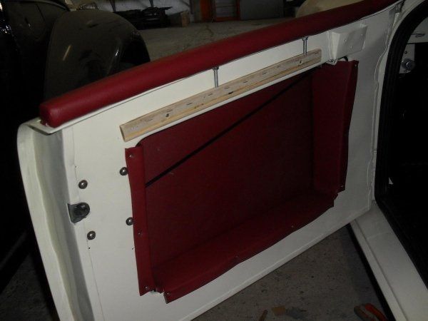 Un'auto bianca con una rifinitura rossa sulla portiera