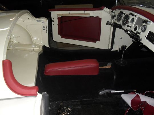 Un'auto bianca con sedili rossi e un volante