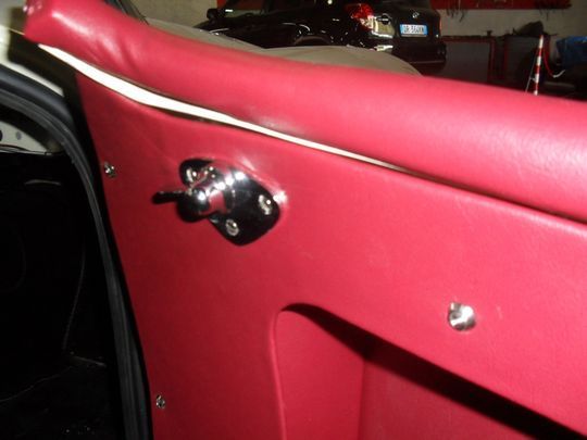 Una portiera di un'auto rossa con un interruttore