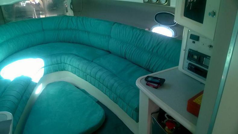 L'interno di una barca con un divano blu e un tavolo.