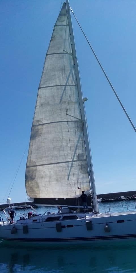 Una barca a vela galleggia su uno specchio d'acqua.