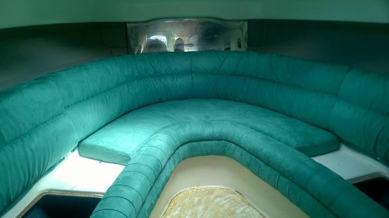 L'interno di una barca con un divano verde e un tavolo.