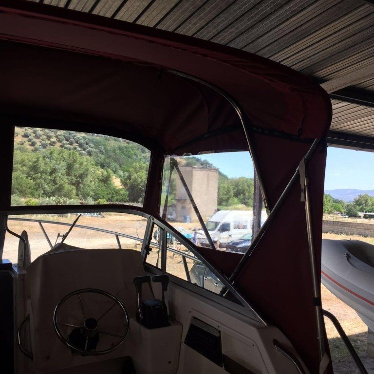 Una barca con un baldacchino rosso e un volante