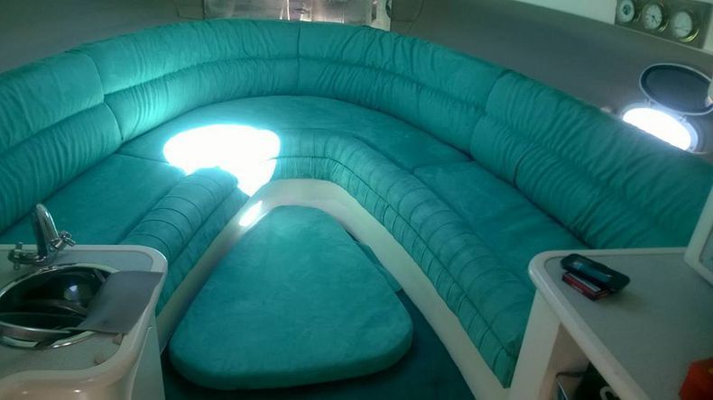 L'interno di una barca con un divano blu e un lavandino.