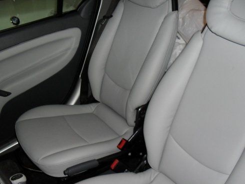 Un'auto con sedili in pelle bianca e cintura di sicurezza rossa