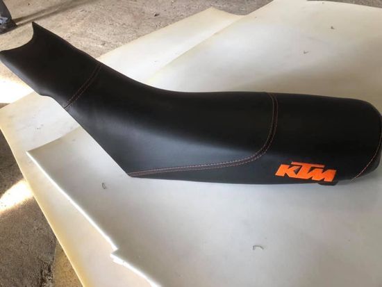 Un sedile di motocicletta nero con la scritta ktm sopra