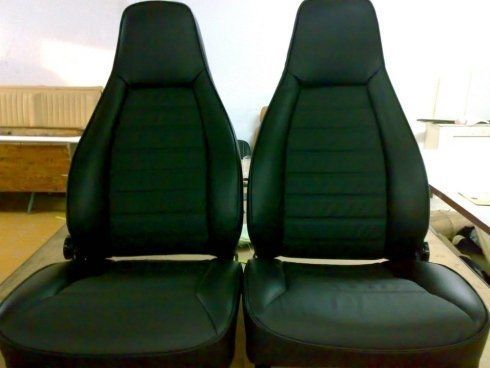 Un paio di sedili in pelle nera per auto uno accanto all'altro