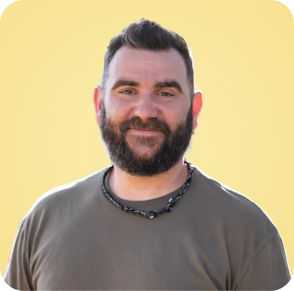 A man with a beard is wearing a necklace around his neck.