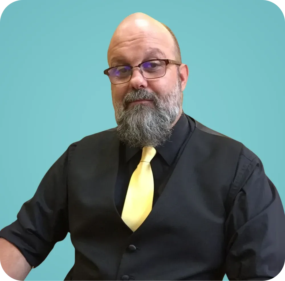 A man with a beard wearing glasses and a yellow tie